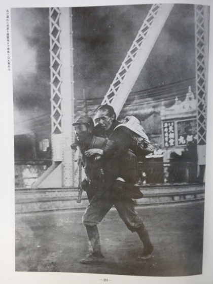 写真集支那事変国書刊行会\P255逃げ遅れた老婆を避難地まで背負う日本軍兵士